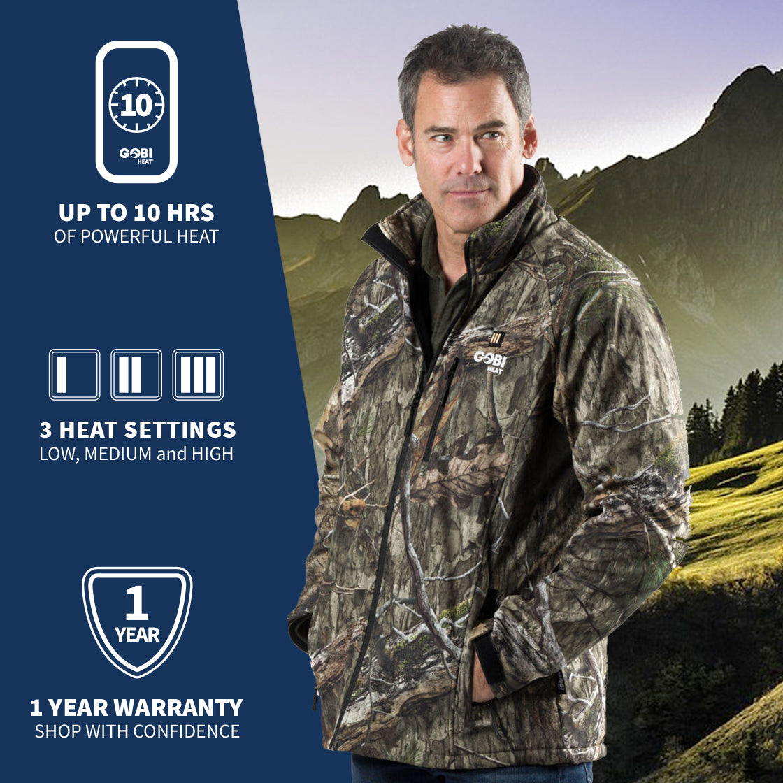 A man wearing GOBI's Men's Sahara Camo heated jacket. He is standing in front of a landscape, with information about the product on the left side of the image.