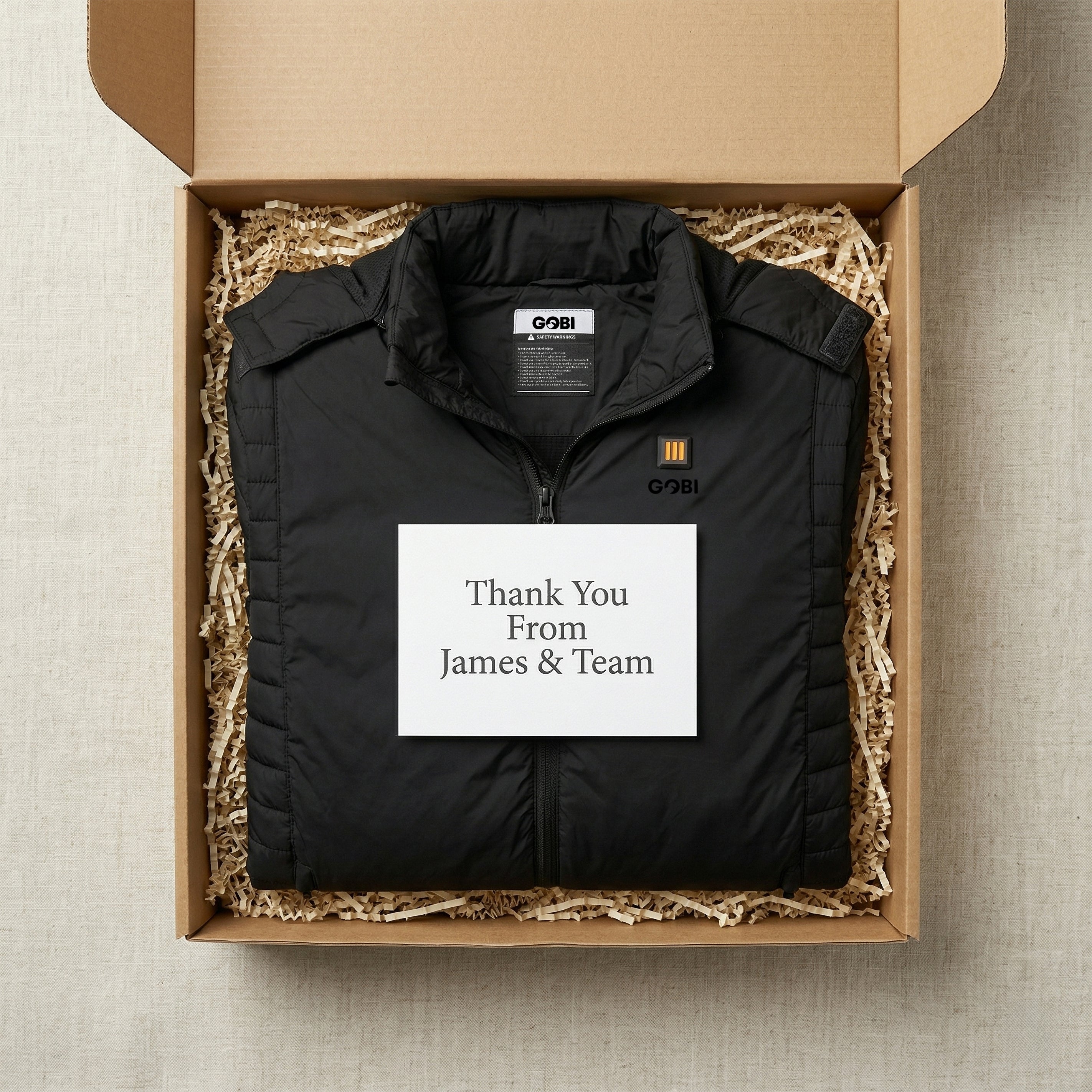 Black jacket in a cardboard box with a 'Thank You From James & Team' card.