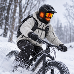 Cyclist wearing the black GOBI Squall heated balaclava while fat biking through snow.